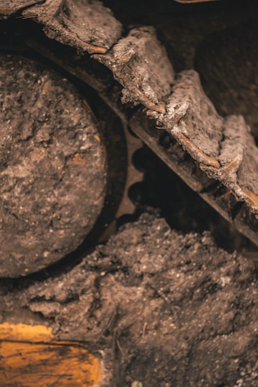Close-up of a rugged D10 dozer undercarriage covered in dirt and ready for heavy work