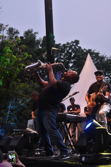 Saxophonist passionately playing on an outdoor evening stage
