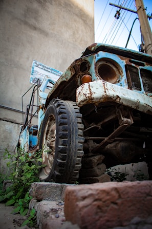Close-up of a junk car being hauled away on a flatbed truck.