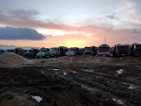 Cargo trucks lined up at a logistics center during sunset.