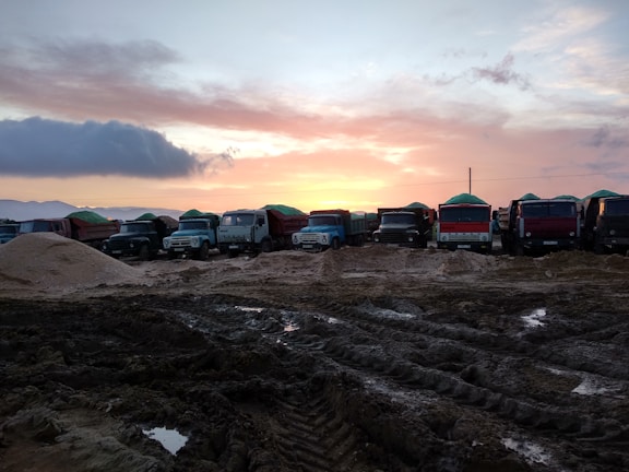 A fleet of trucks lined up at sunrise, ready for a day's haul.
