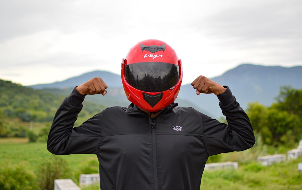 man in black leather jacket wearing red helmet