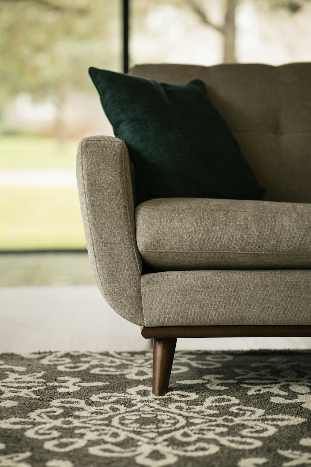 gray sofa chair on white and black area rug