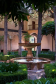 A serene courtyard garden at a boutique hotel with blooming flowers and stone pathways under soft sunlight.