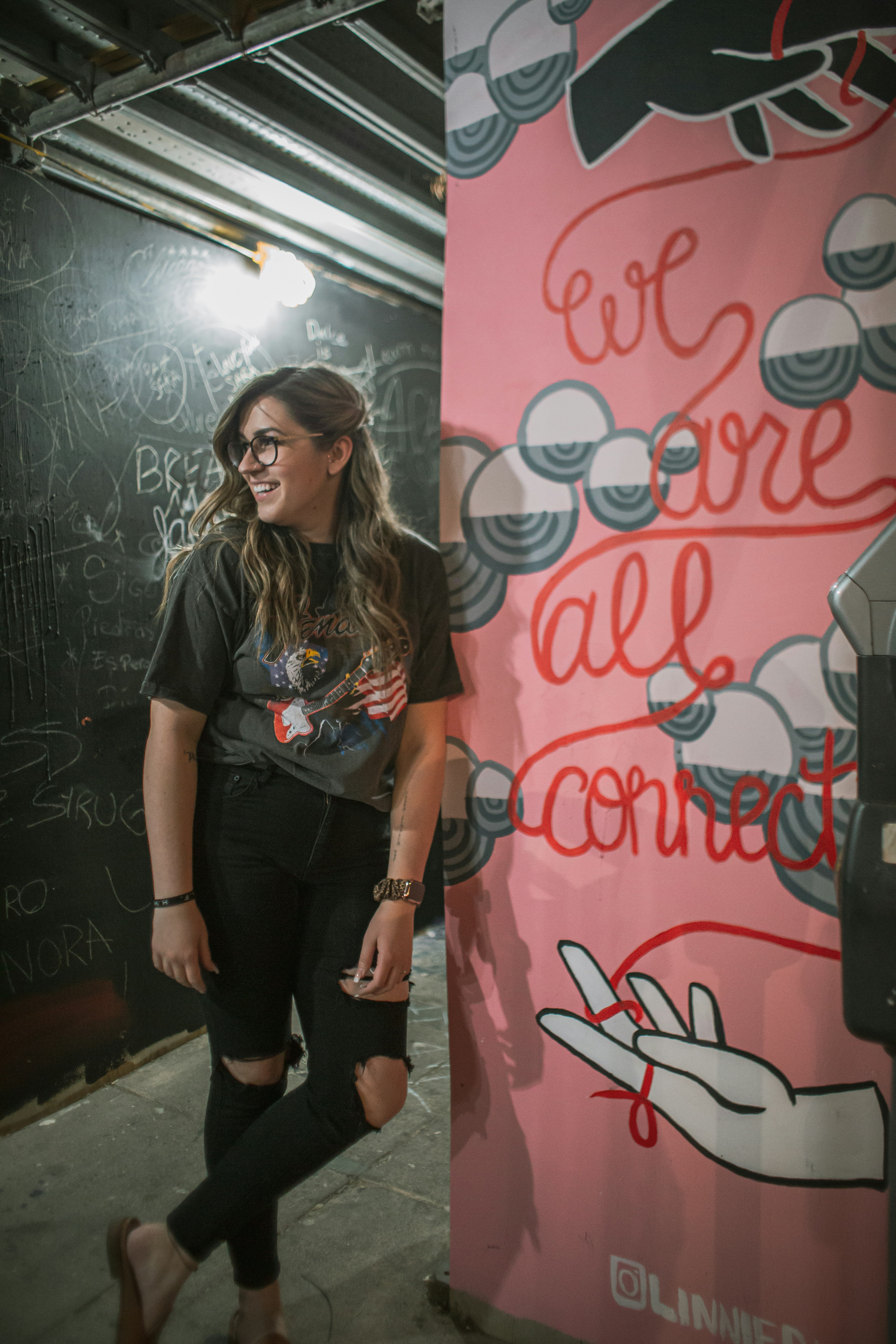 woman in black and white floral shirt standing beside white and red wall
