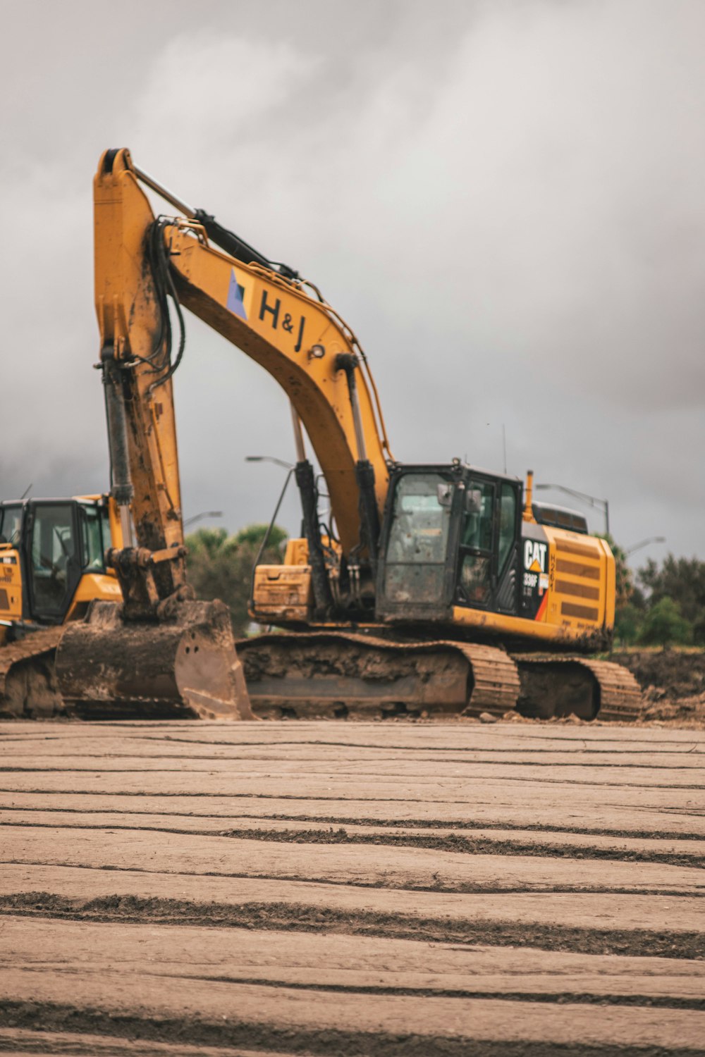 yellow and black excavator on brown wooden dock during daytime