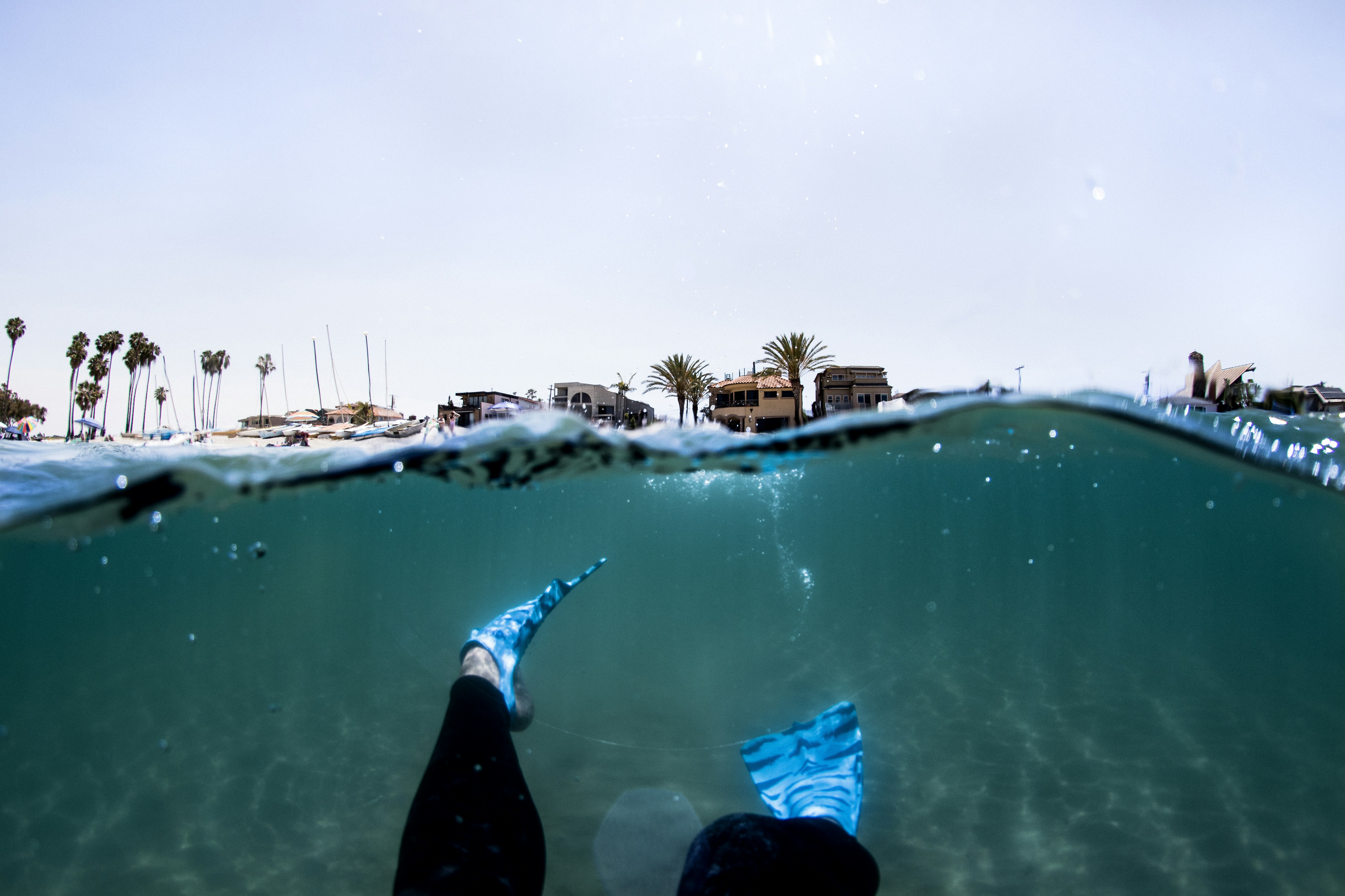 person in black pants in water