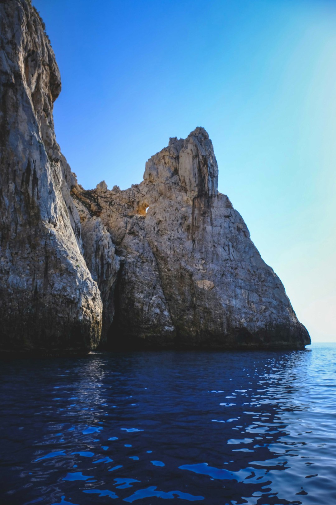 brown rock formation on blue sea under blue sky during daytime