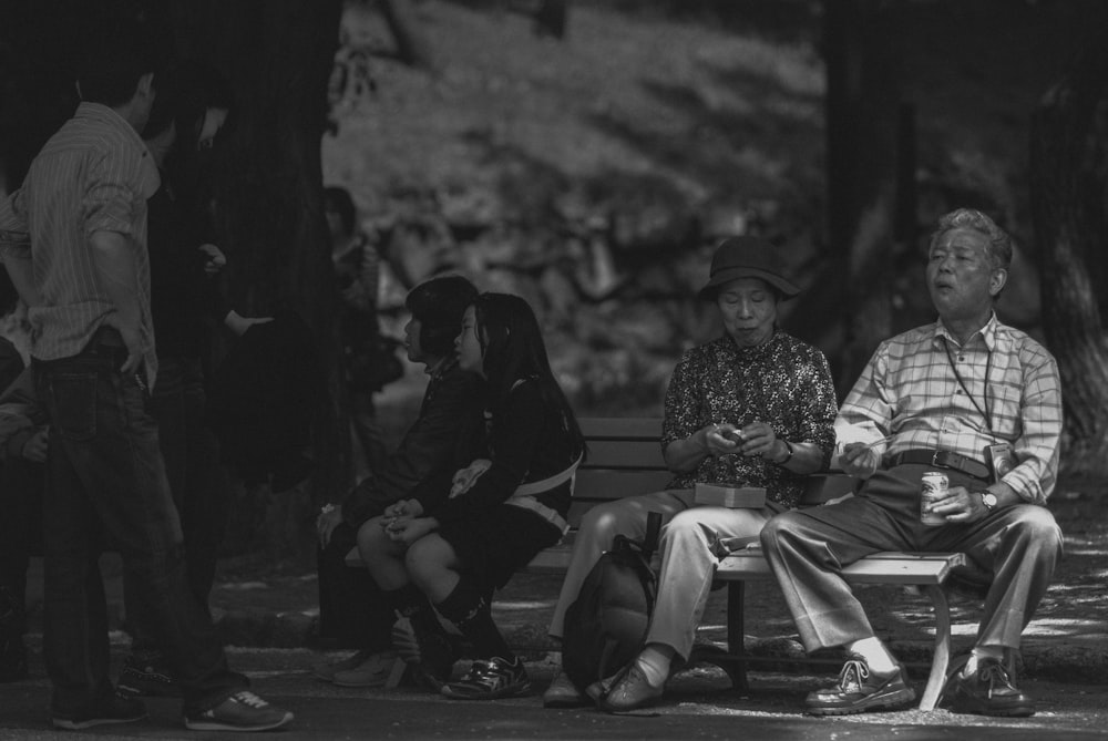 Foto in scala di grigi di uomo e donna seduti sulla panchina