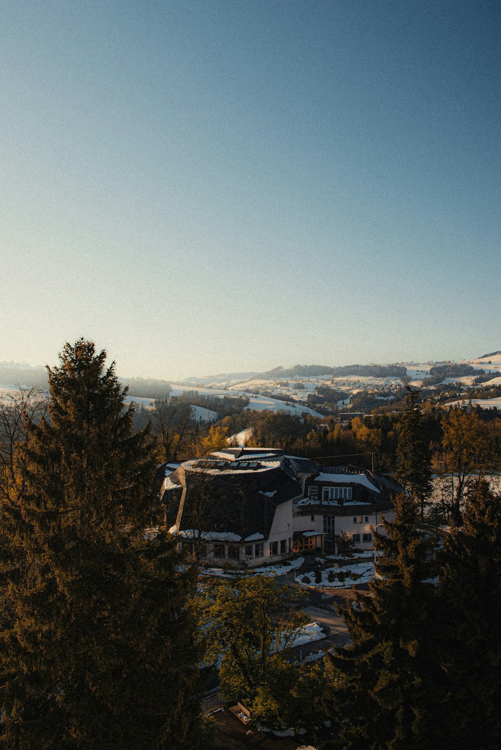 weißes und braunes Haus, tagsüber von Bäumen umgeben