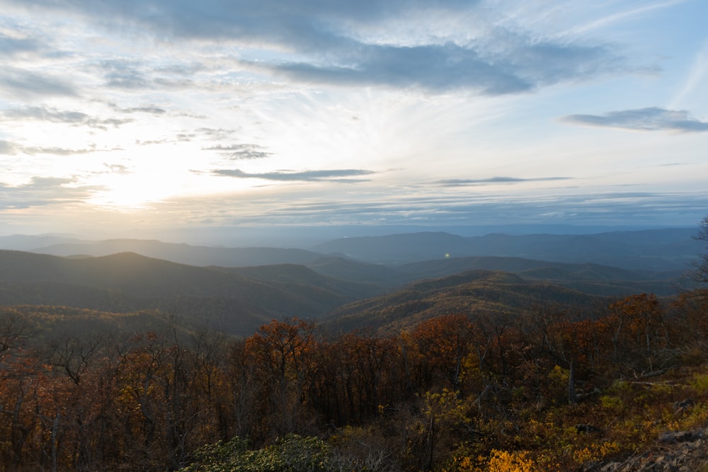 the sun is setting over the mountains in the distance