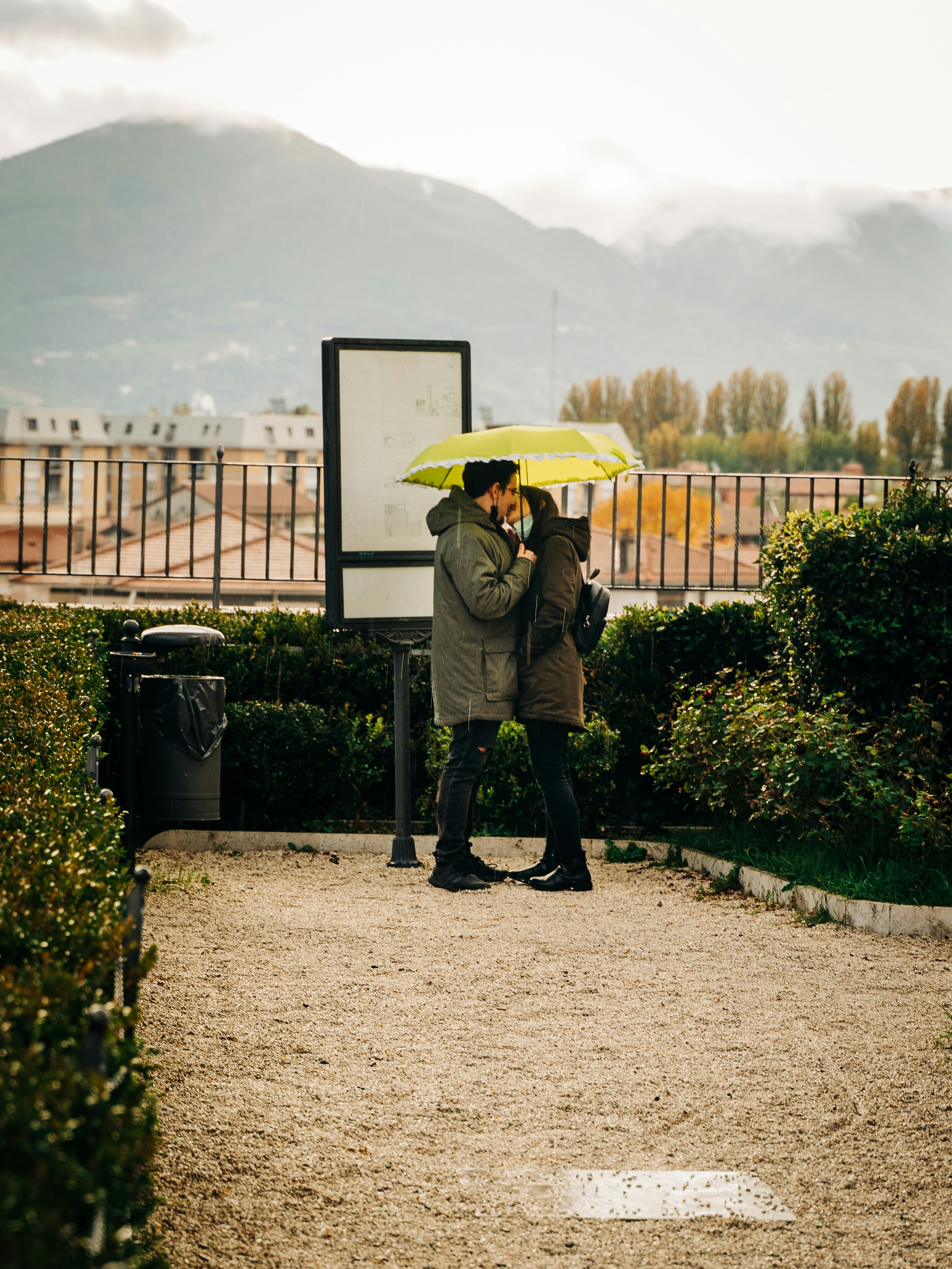 person in gray jacket and black pants holding yellow umbrella