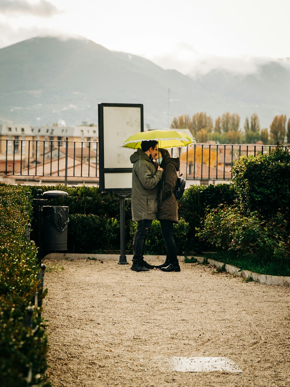 person in gray jacket and black pants holding yellow umbrella