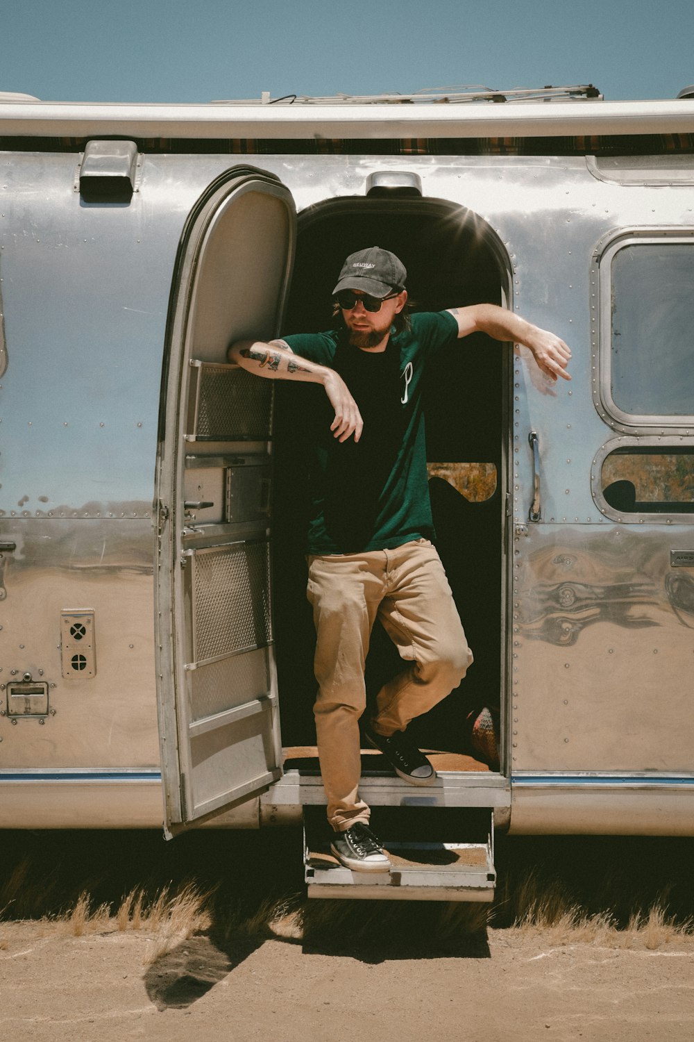 man in black t-shirt and brown pants sitting on gray bus