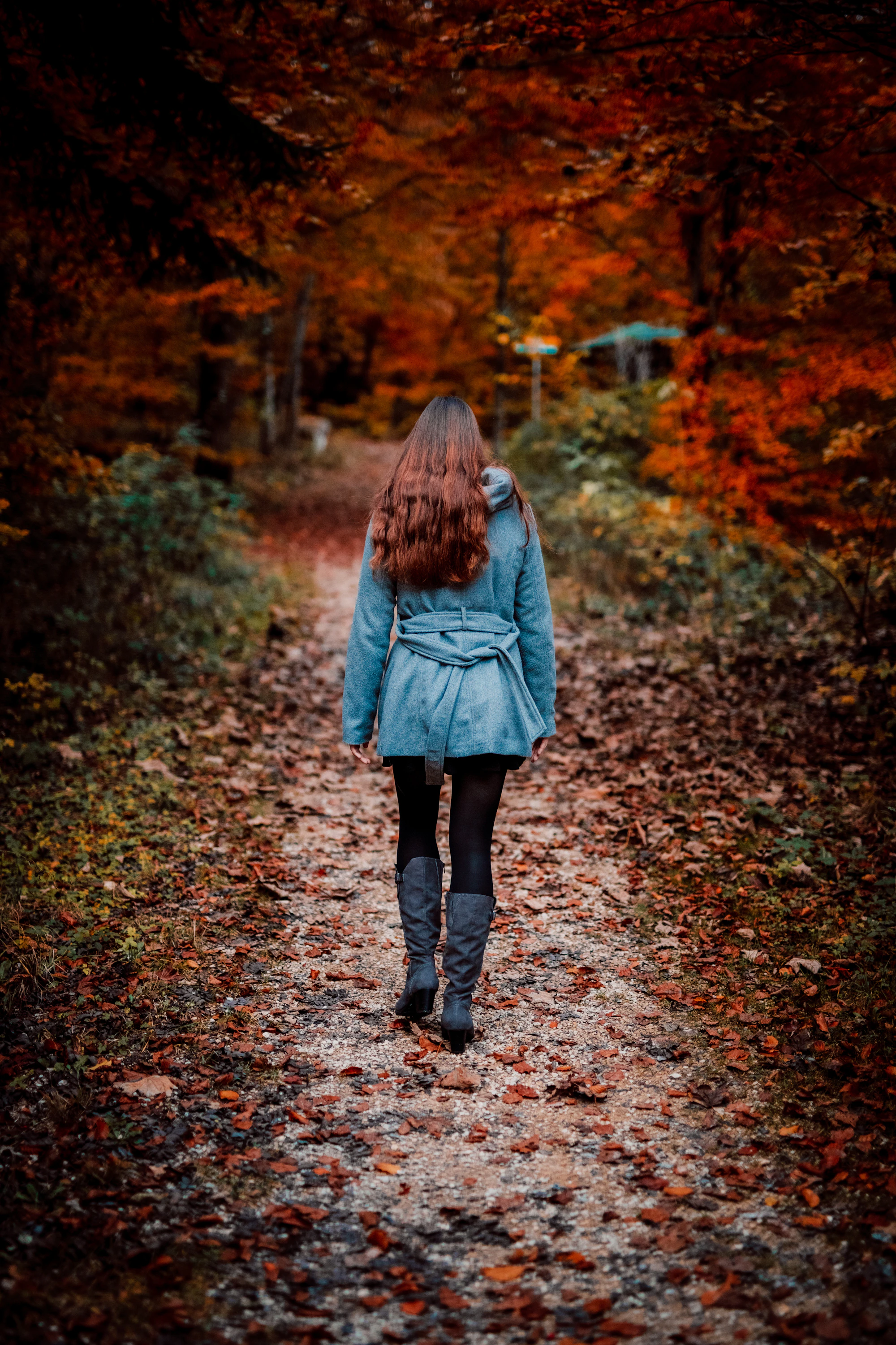 A woman walking a quiet path in warm afternoon light, unhurried.