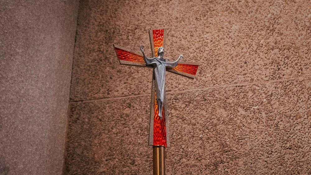 silver and red cross on brown floor