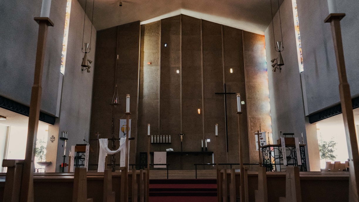 A serene church interior with soft lighting and wooden pews, inviting reflection and worship.