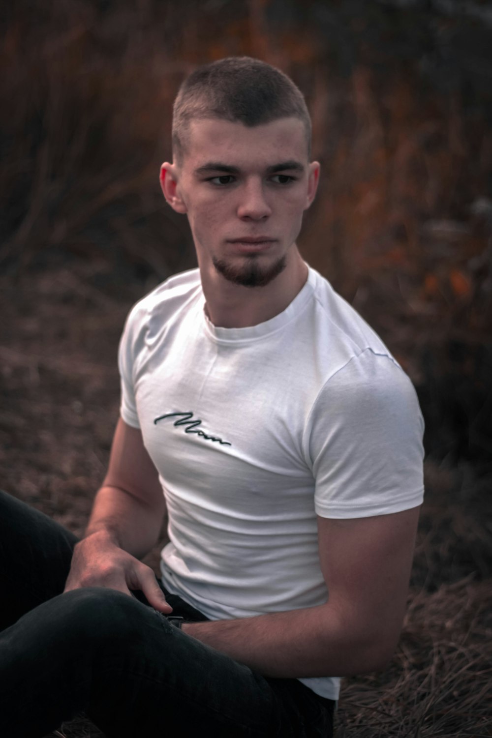 man in white crew neck t-shirt sitting on black leather chair