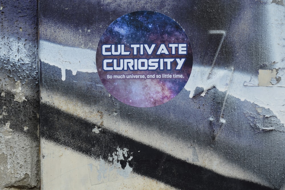 a sticker on the side of a building that says cultivate curiosity