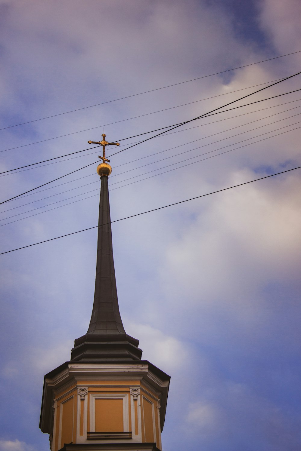 gray concrete cross under cloudy sky during daytime