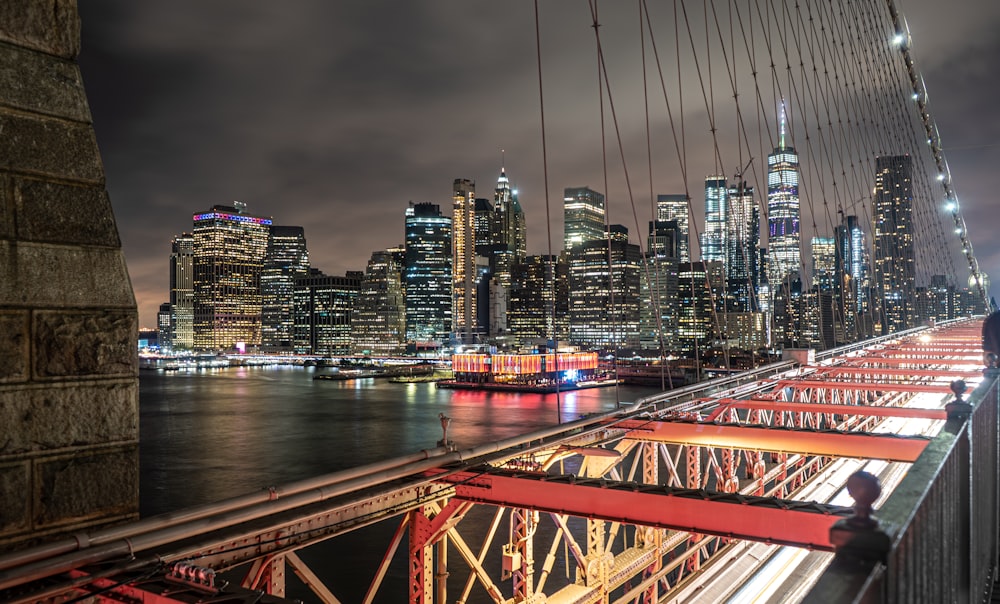 red metal bridge over river during night time