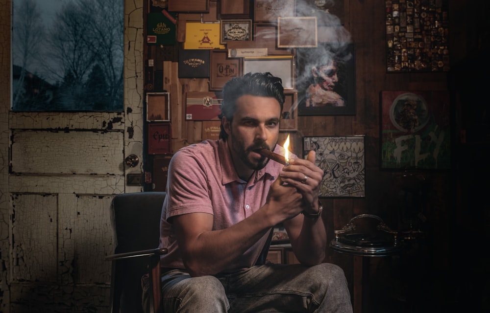 man in pink polo shirt smoking cigarette