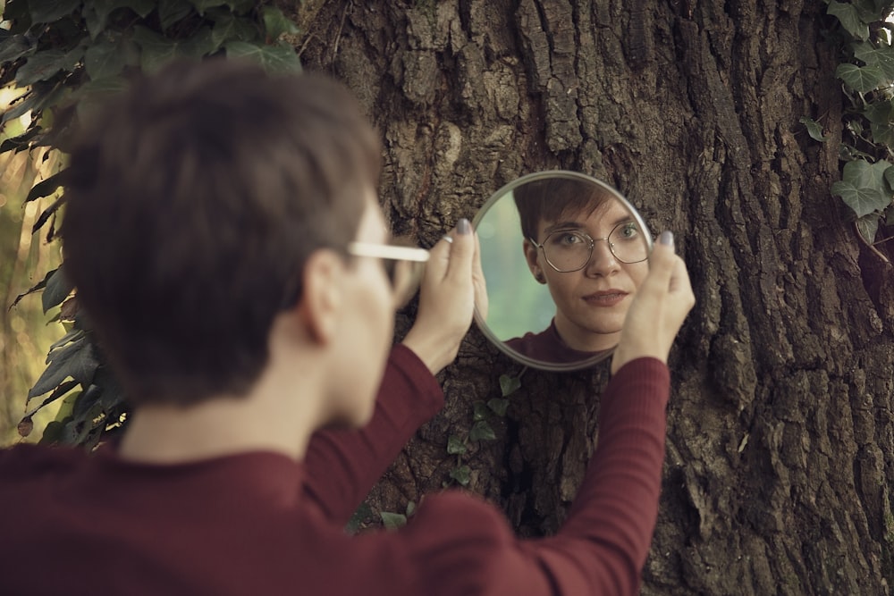 woman in red sweater holding magnifying glass