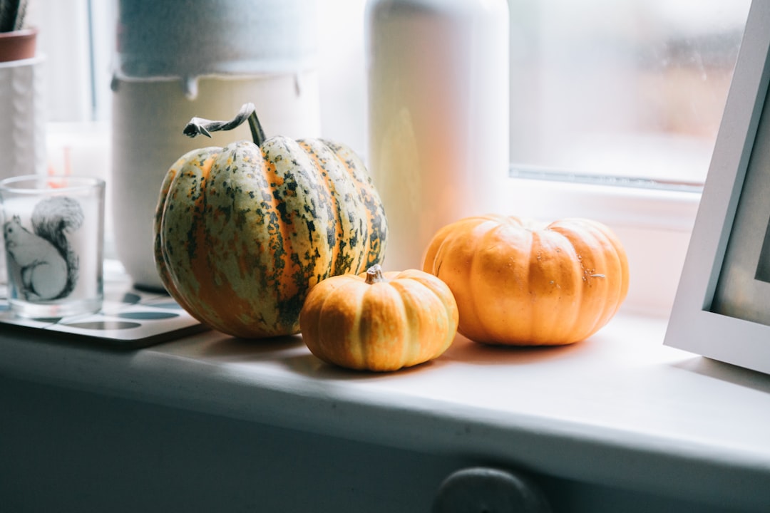 orange and green pumpkin on white table