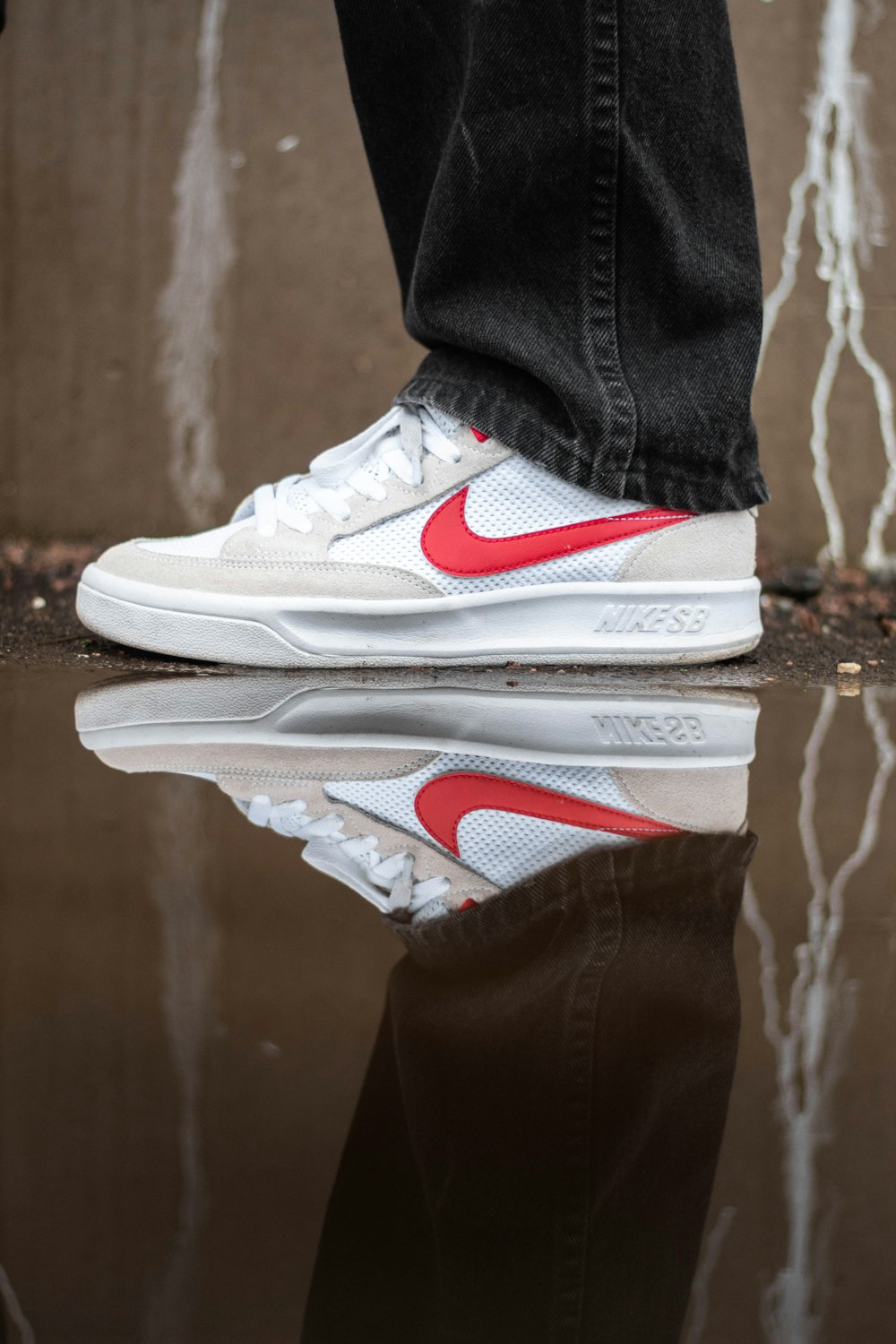 person wearing white and red nike athletic shoes