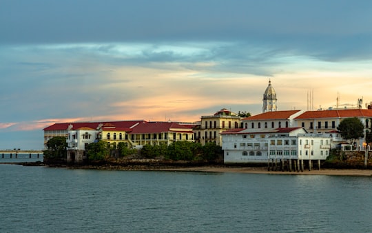 white and brown concrete building near body of water during daytime in Casco Antiguo Panama