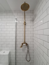 gold shower head on white ceramic bathtub