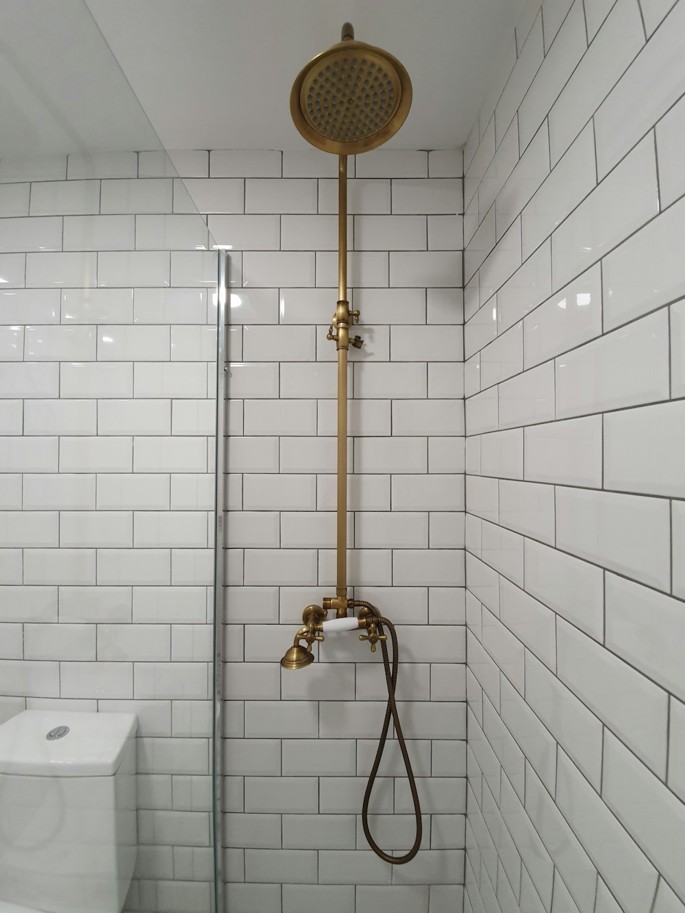 chuveiro dourado na banheira de cerâmica branca