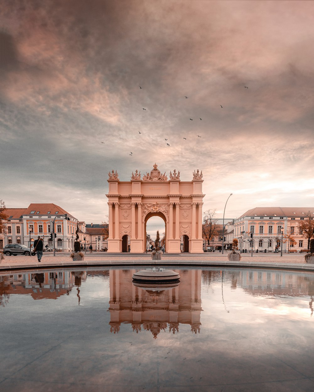 edificio in cemento marrone vicino alla fontana d'acqua durante il giorno