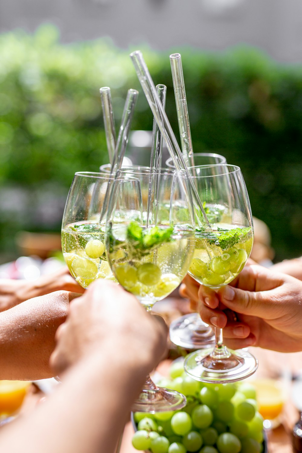 person holding clear wine glass with yellow liquid