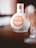 A bottle of Mozart White Chocolate Vanilla Cream liqueur sits on a wooden surface with its decorative packaging. The background is softly blurred, adding elegance to the presentation.