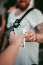 person holding clear plastic cup with black plastic straw
