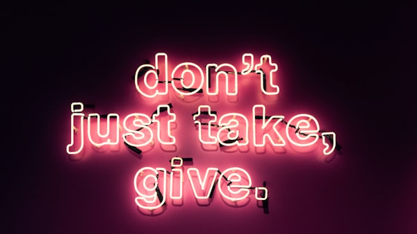 a neon sign reading "don't just take, give." 