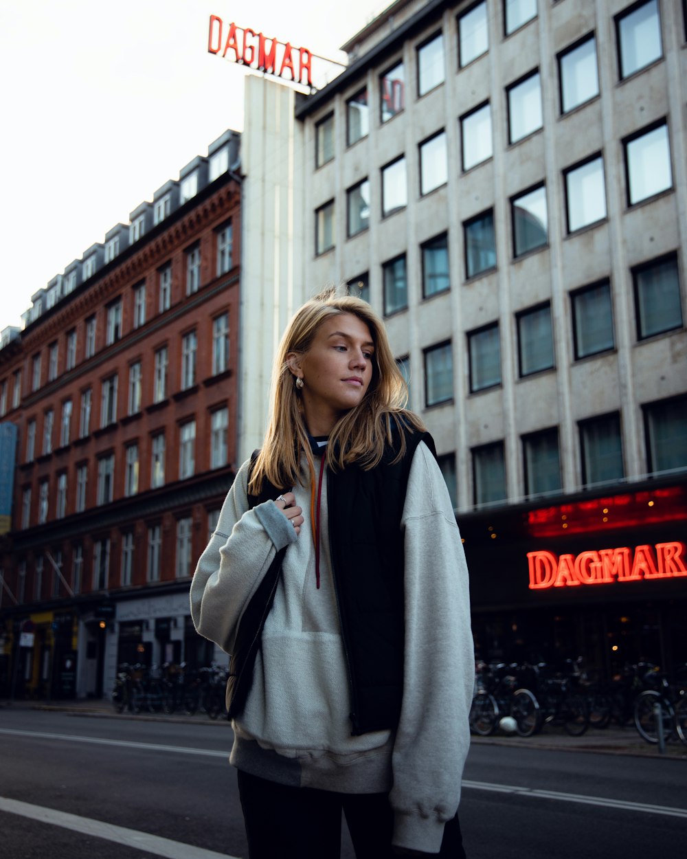 woman in gray coat standing on road during daytime