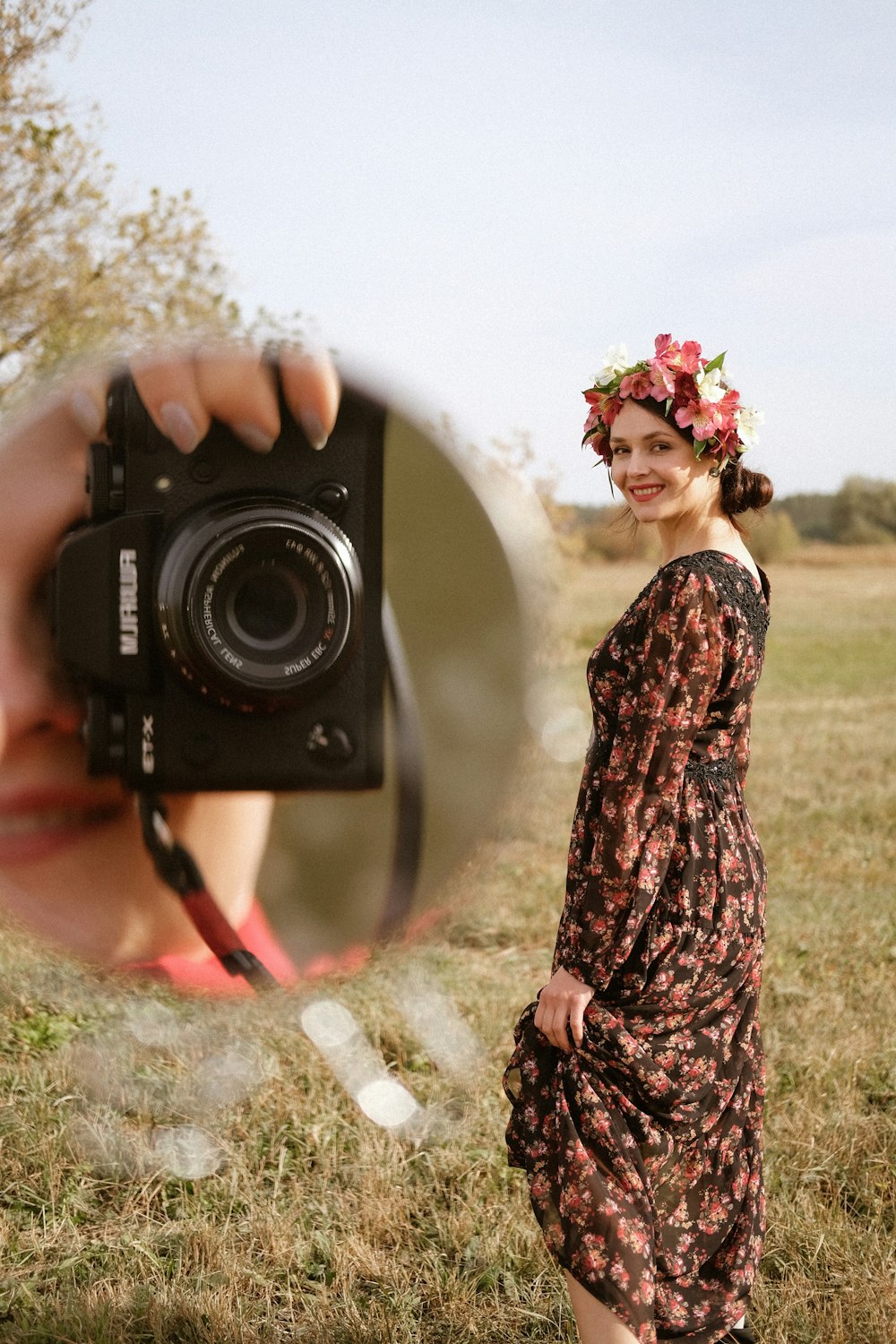 woman in black and brown floral dress holding black nikon dslr camera