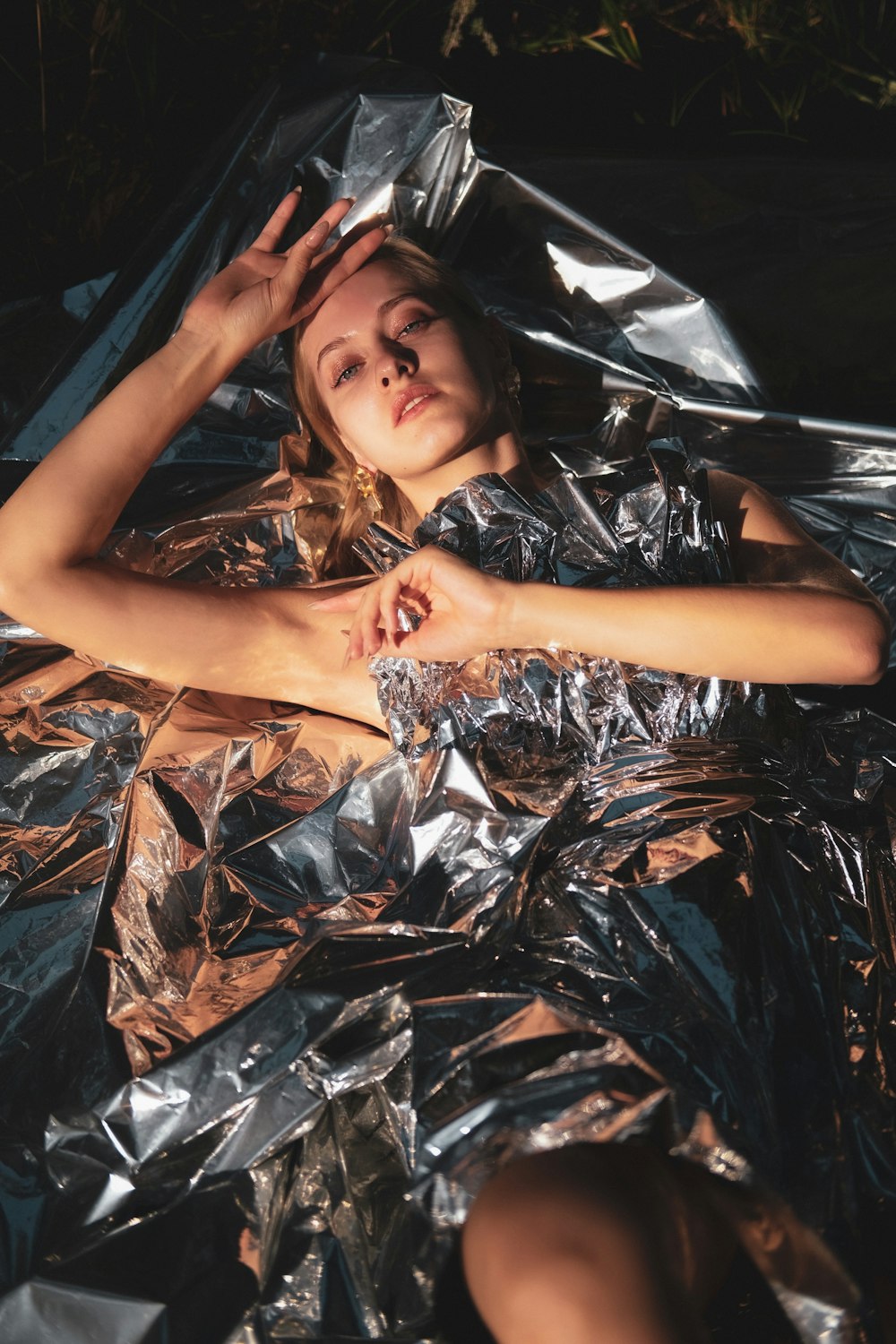 woman in black and white floral dress lying on black plastic bag