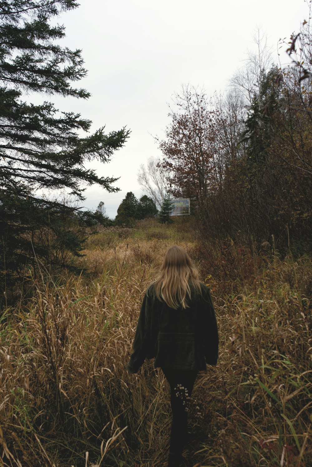 woman in black jacket standing on green grass field during daytime