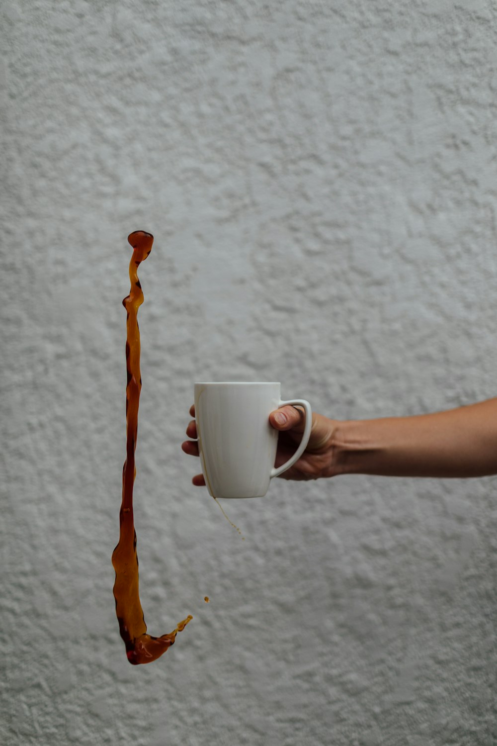 pessoa segurando caneca de cerâmica branca