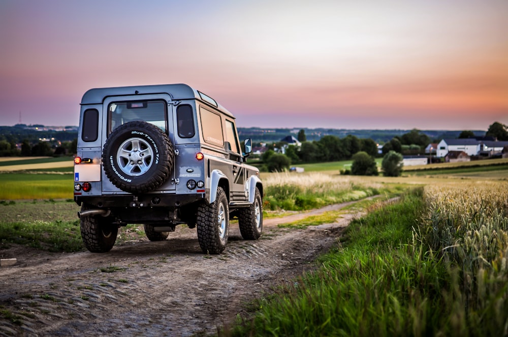 Schwarzer Jeep Wrangler tagsüber auf Feldweg