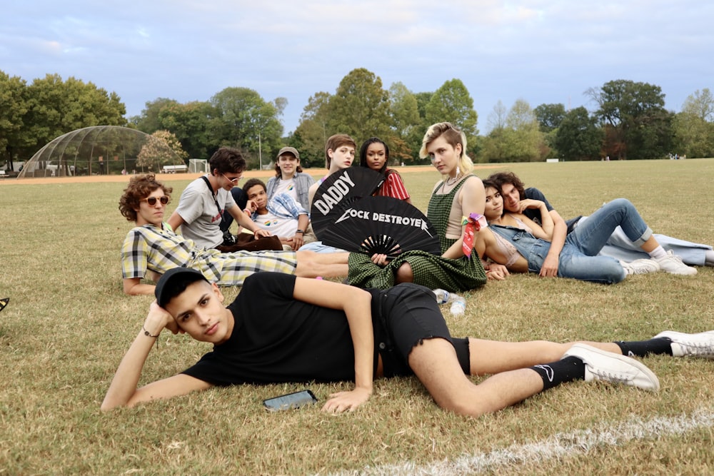 group of people sitting on green grass field during daytime