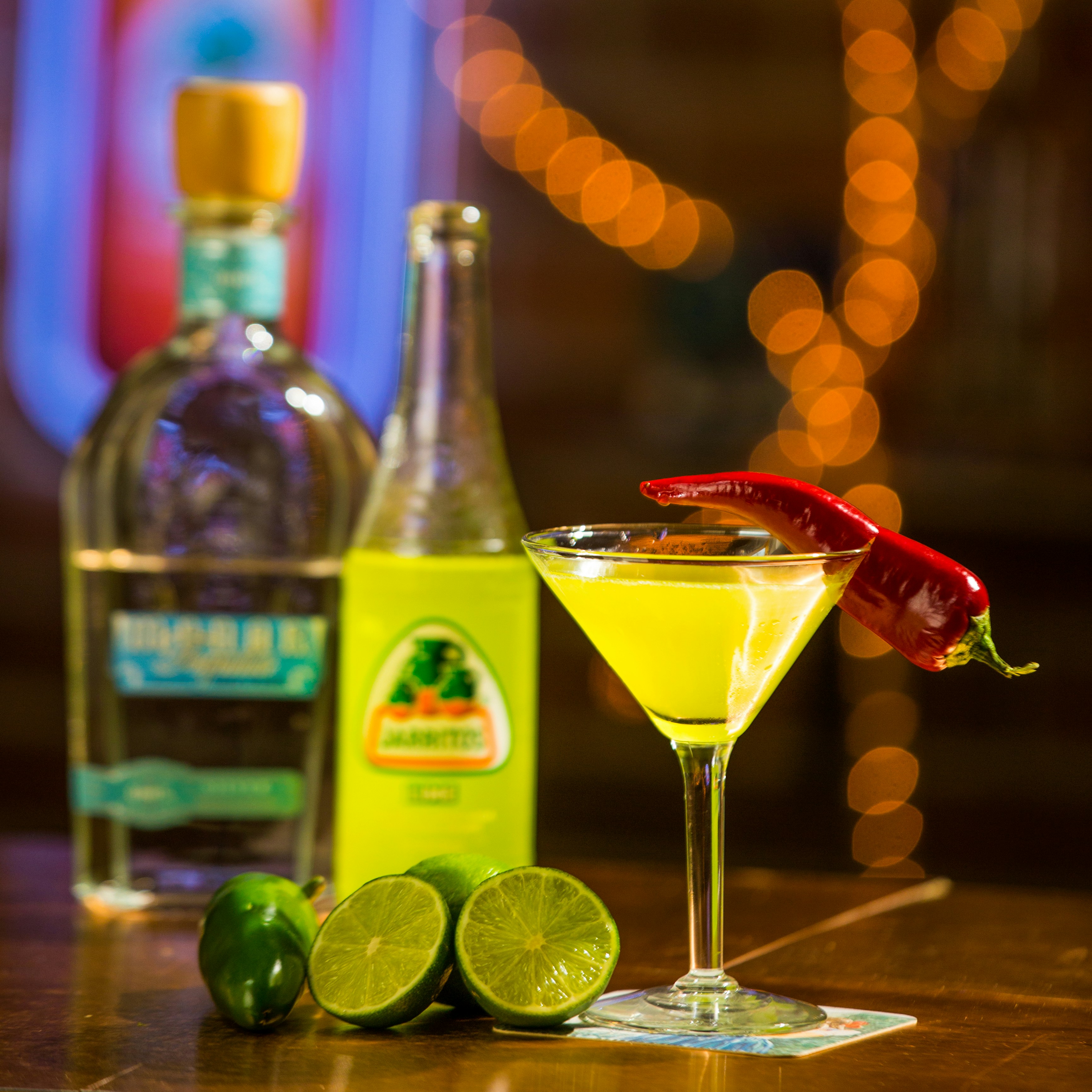 赤い液体が入った透明なコップの横にある透明なガラス瓶