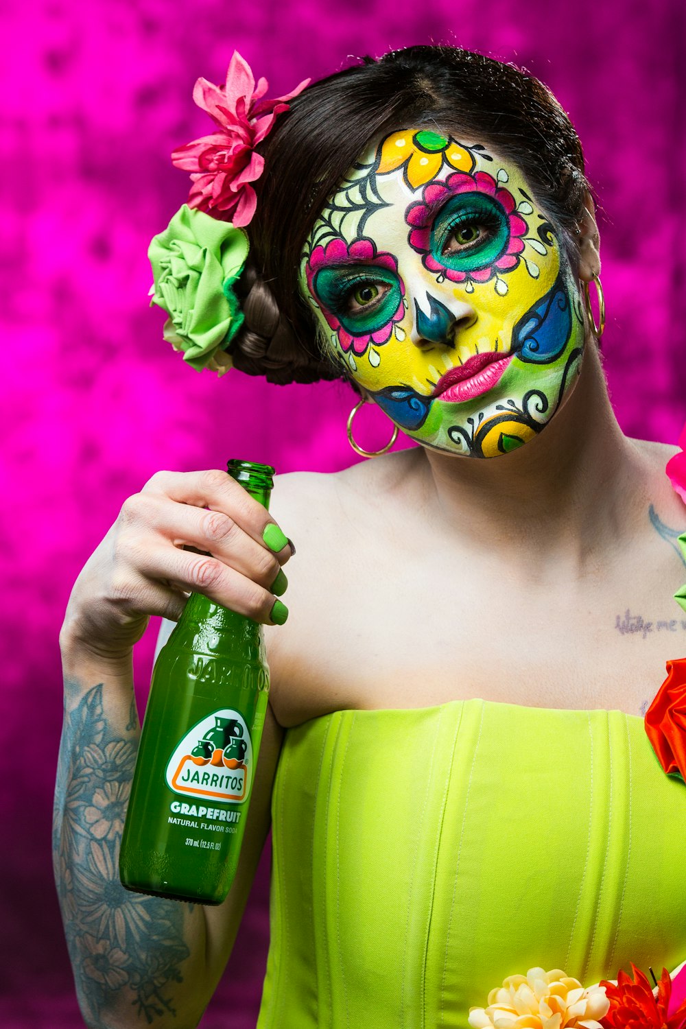 Frau in grüner und gelber Maske mit grüner Flasche