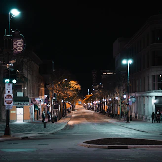 Close-up of a glowing streetlight illuminating a quiet urban street at night