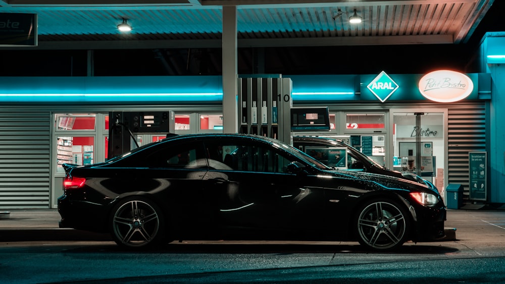 Porsche 911 negro aparcado frente a la tienda