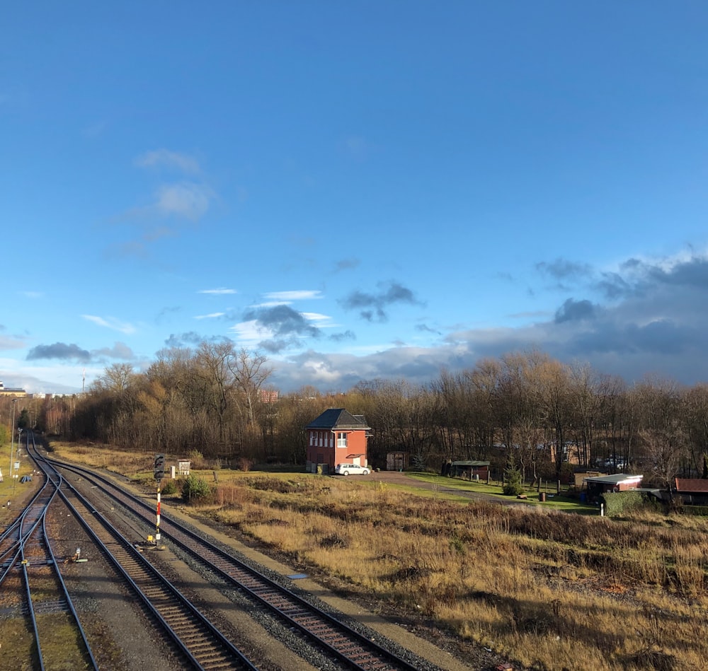 Braunes Haus auf grünem Rasenplatz unter blauem Himmel tagsüber