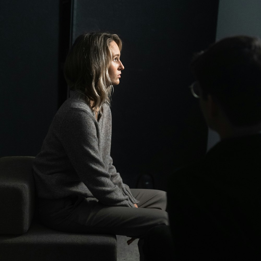 woman in gray long sleeve shirt sitting beside man in gray suit